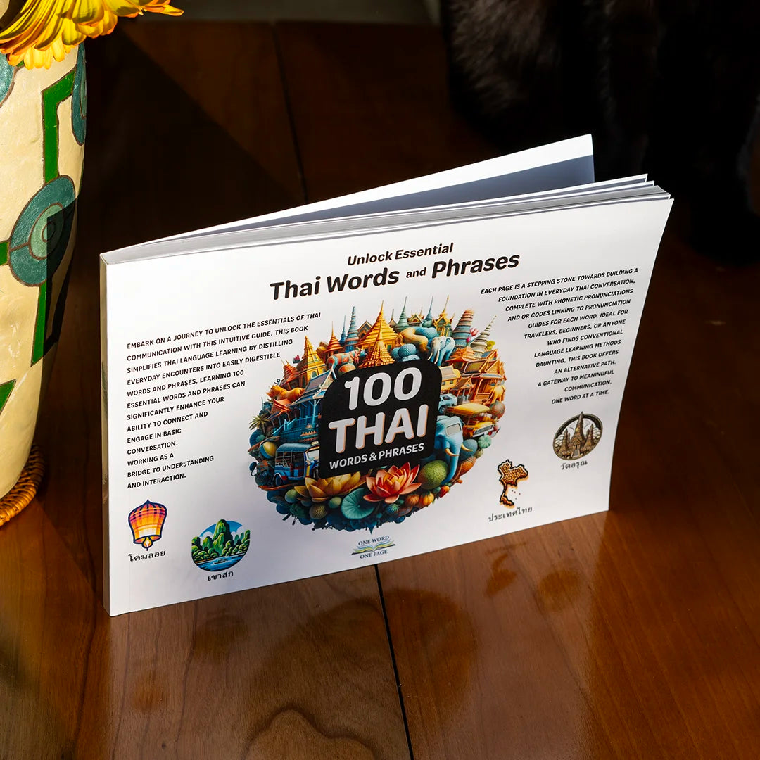 100 Thai Words and Phrases language book sitting on a wood table in a house.